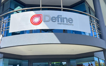 Curved exterior building signage for Define Instruments with 3D logo and lettering mounted on fascia above entrance
