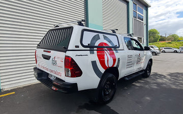 White utility vehicle featuring FPS Fire Protection Specialists branding, including services like building compliance, fire alarms, and fire extinguishers.