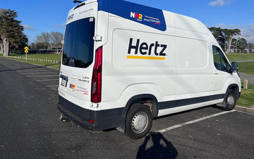 White LDV Deliver 9 van branded with Hertz logo and NHR Group commercial leasing signage, parked outdoors on a sunny day.