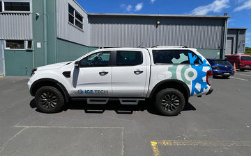 White ICE TECH branded ute with large gear graphics and company logo, parked outside a commercial facility, showcasing industrial engineering vehicle signage.