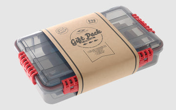 Gift pack by Ocean Angler featuring a clear tackle box with red clips and kraft paper wrap, showcasing locally designed snapper fishing lures and accessories.
