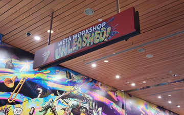 Hanging ceiling sign for Wētā Workshop Unleashed with bold, colourful 3D lettering and vibrant creative graphics