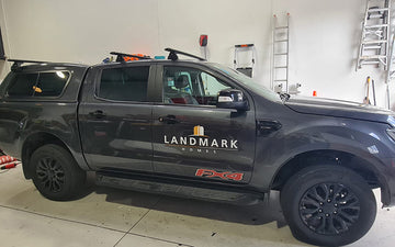 Dark grey utility vehicle featuring Landmark Homes logo, parked indoors and fitted for construction and residential building services.
