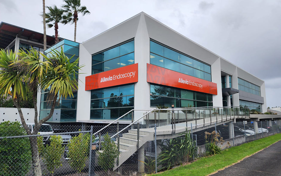 Allevia Endoscopy building exterior with bold orange fascia signage installed on a modern glass-front medical facility
