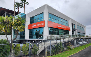 Allevia Endoscopy building exterior with bold orange fascia signage installed on a modern glass-front medical facility